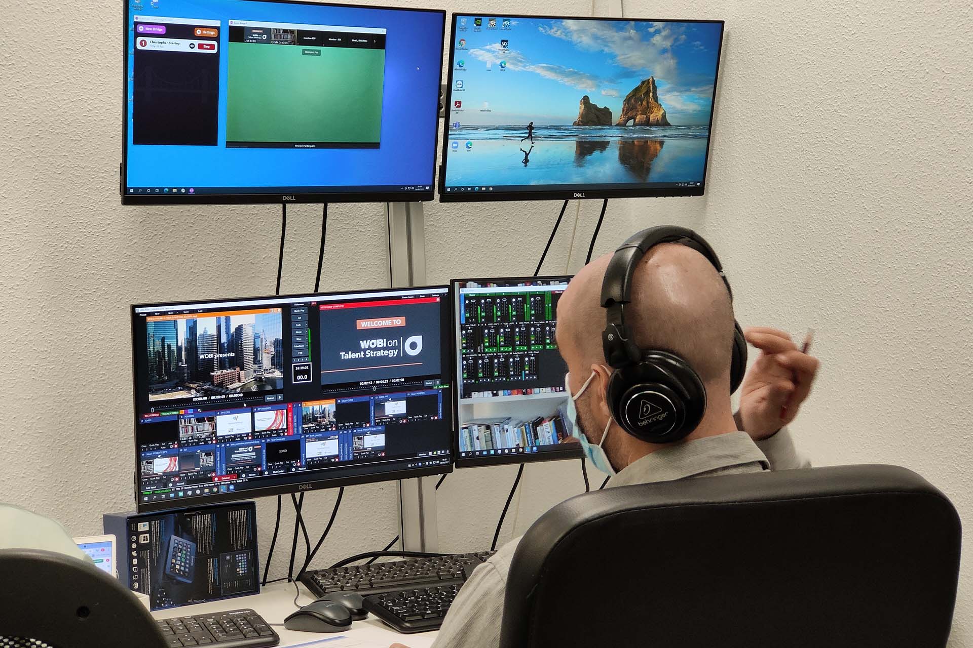 Photograph of operator and screens in the production room during the broadcast of a live online event